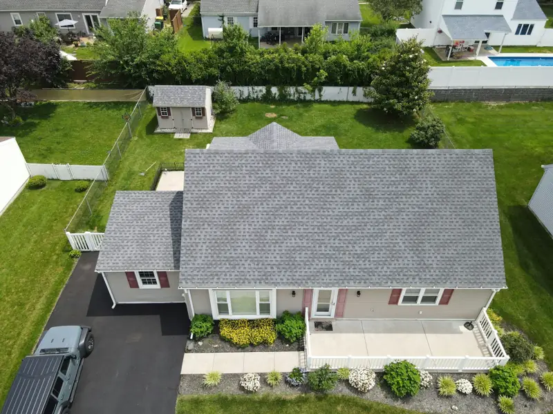 Aerial view of a ranch home with a new gray shingle roof